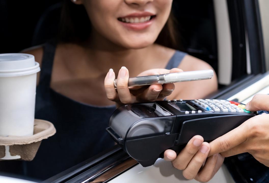 Is it illegal to use my phone to pay in the drive-thru or for parking?