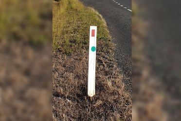 What do those green stickers on roadside posts mean?