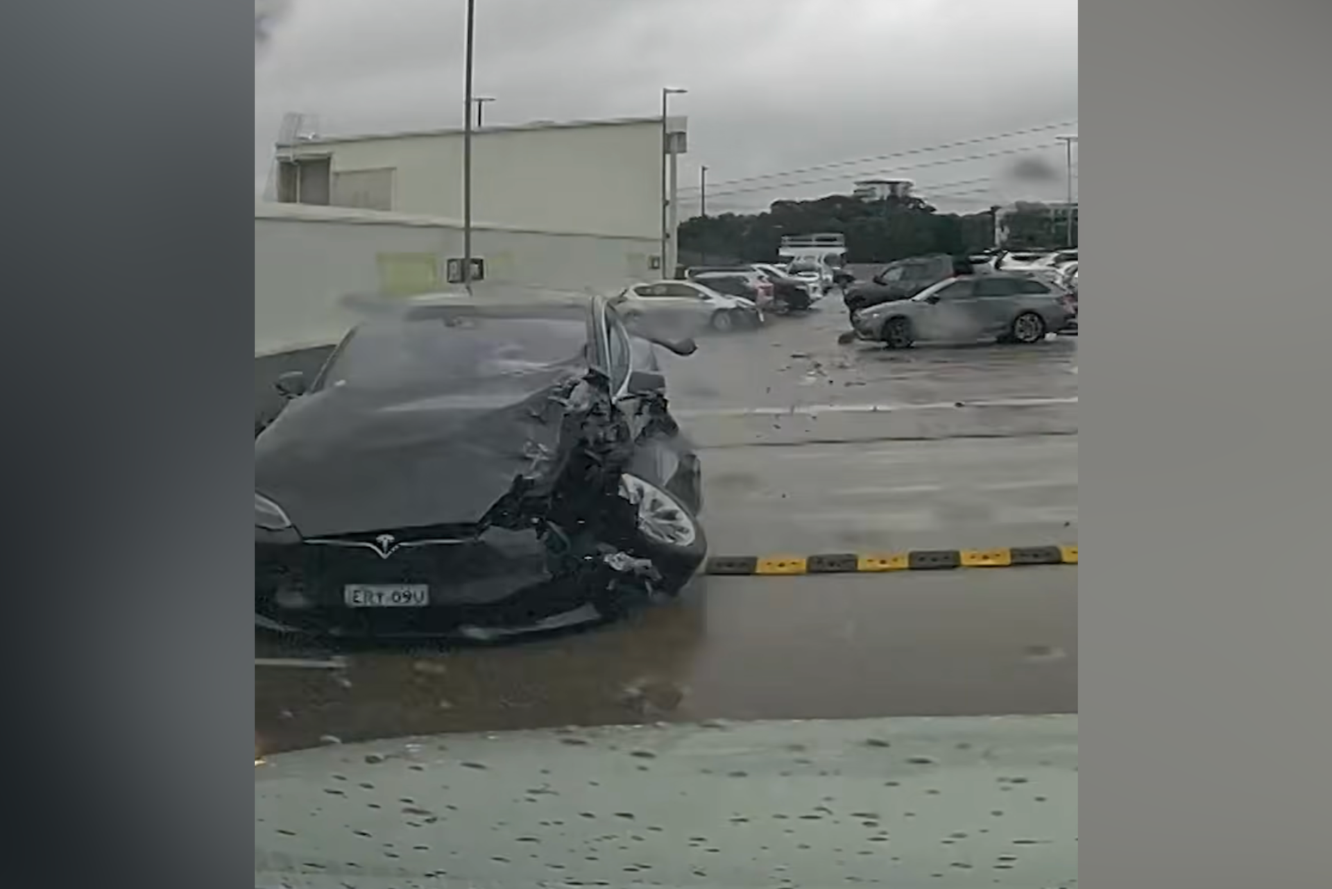 Out-of-control Tesla crashes into cars, plunges off carpark roof ...