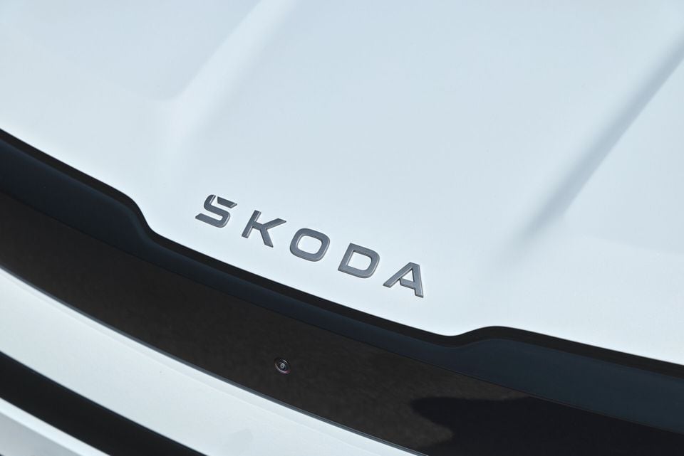 Close-up of the Skoda wordmark badge on the front of a white Skoda Epiq