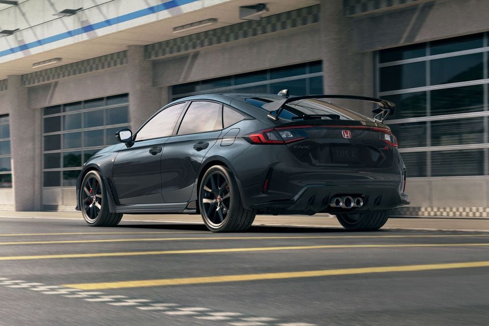 A dark grey 2027 Honda Civic Type R hatchback parked on a road, seen from the rear quarter.