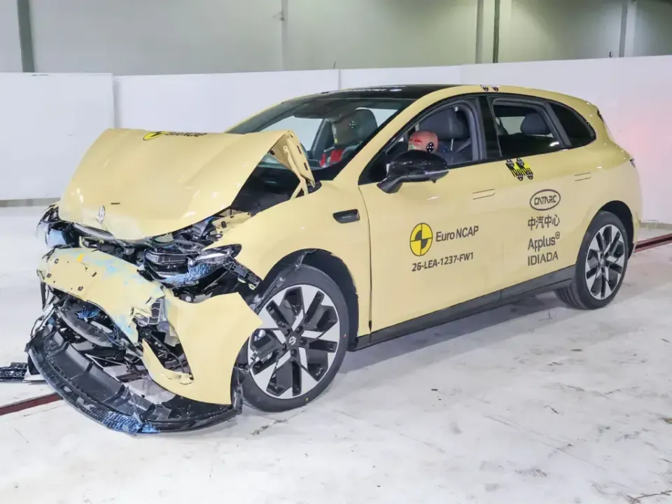 A Leapmotor hatchback with severe front-end crash damage after a Euro NCAP frontal impact test, showing a crumpled bonnet and destroyed front bumper