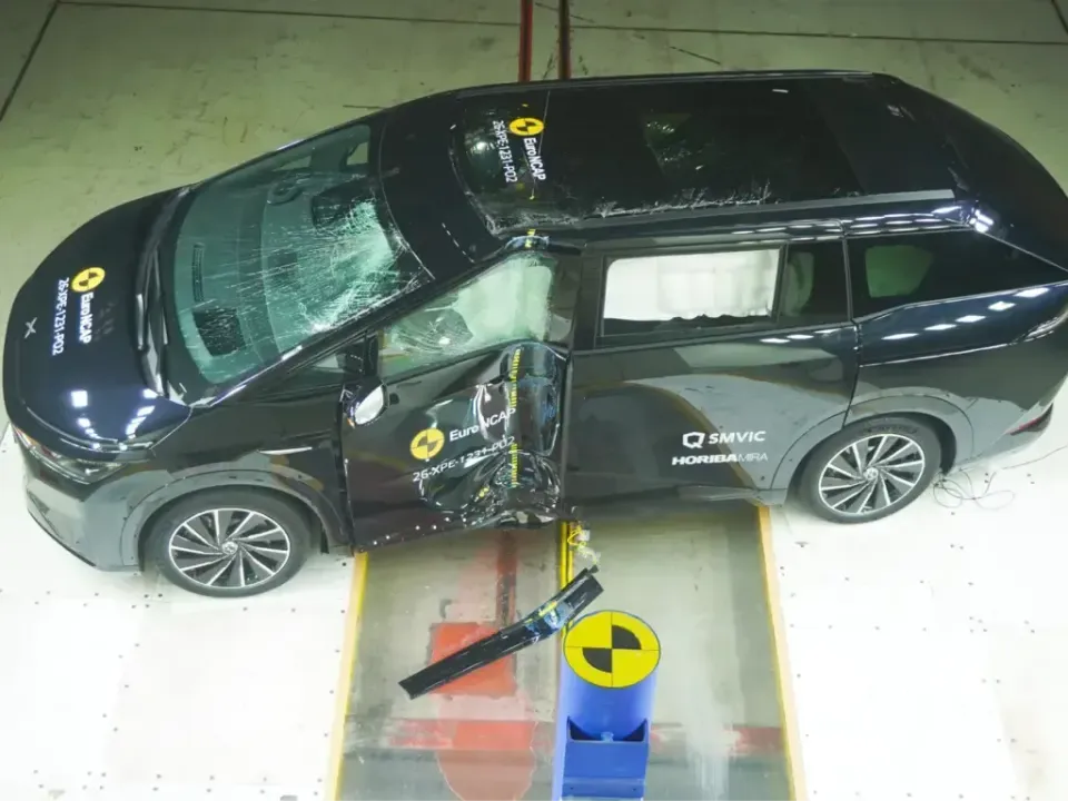 A black Xpeng X9 people mover seen from above after a Euro NCAP side pole crash test, with a crumpled driver's door and deployed curtain airbags