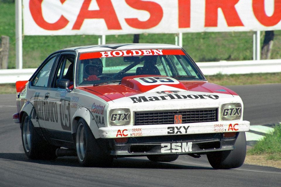 A Holden Torana A9X race car number 05 with Marlboro and Holden livery competing on a circuit, seen from the front at an angle, with a Castrol banner in the background