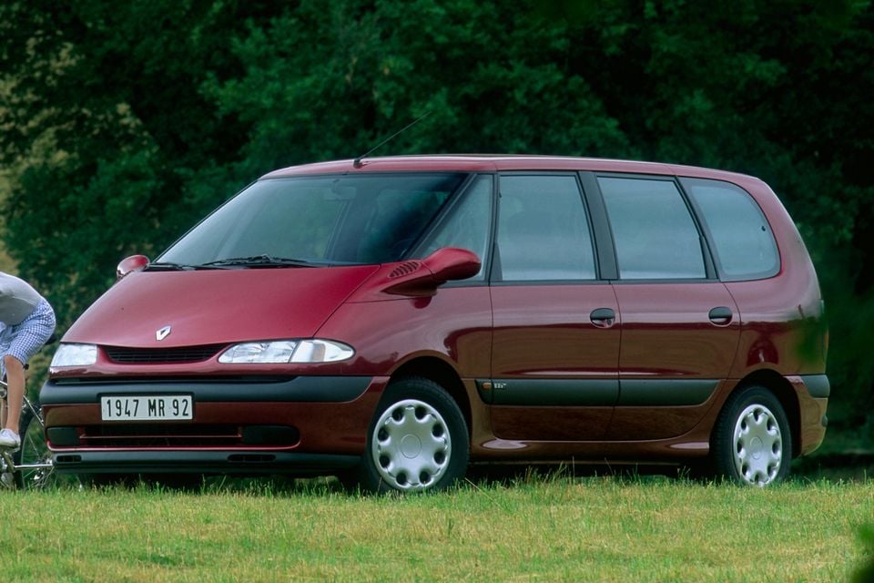 Uma minivan Renault Espace III marrom 1996 estacionada na grama, vista da frente.