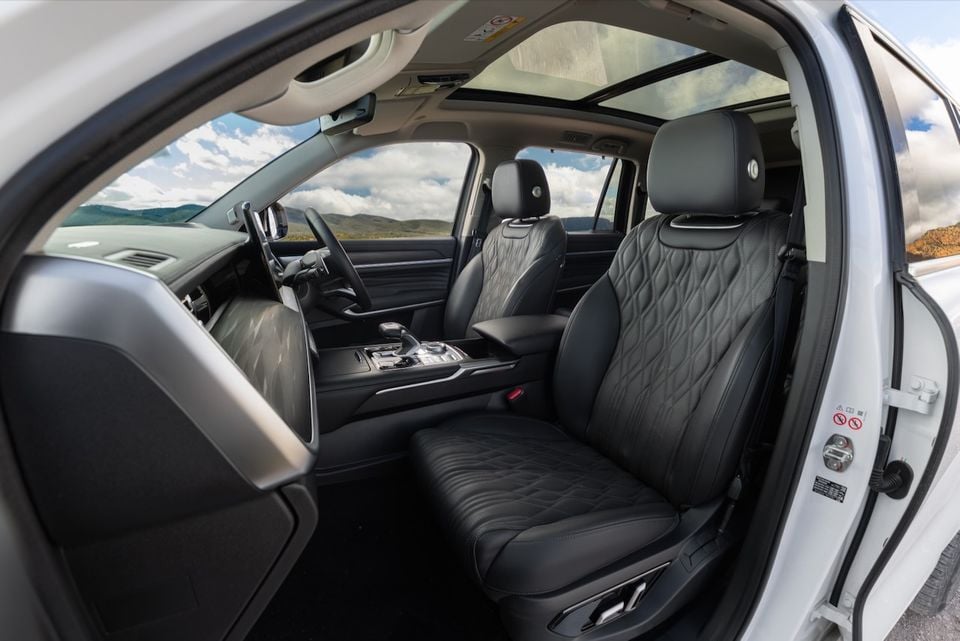 The black leather front seats and dashboard of a 2026 GWM Tank 500 SUV, viewed through the open driver's door with a large sunroof visible