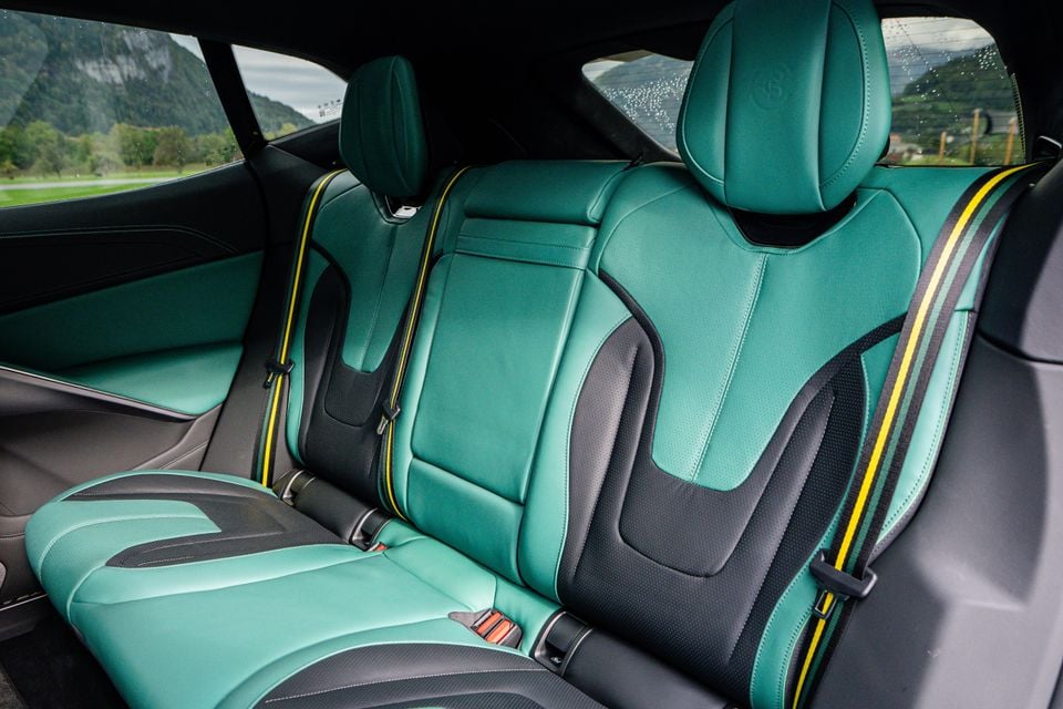 Rear seats of a 2027 Lotus Eletre X trimmed in green and black leather with yellow-striped seatbelts