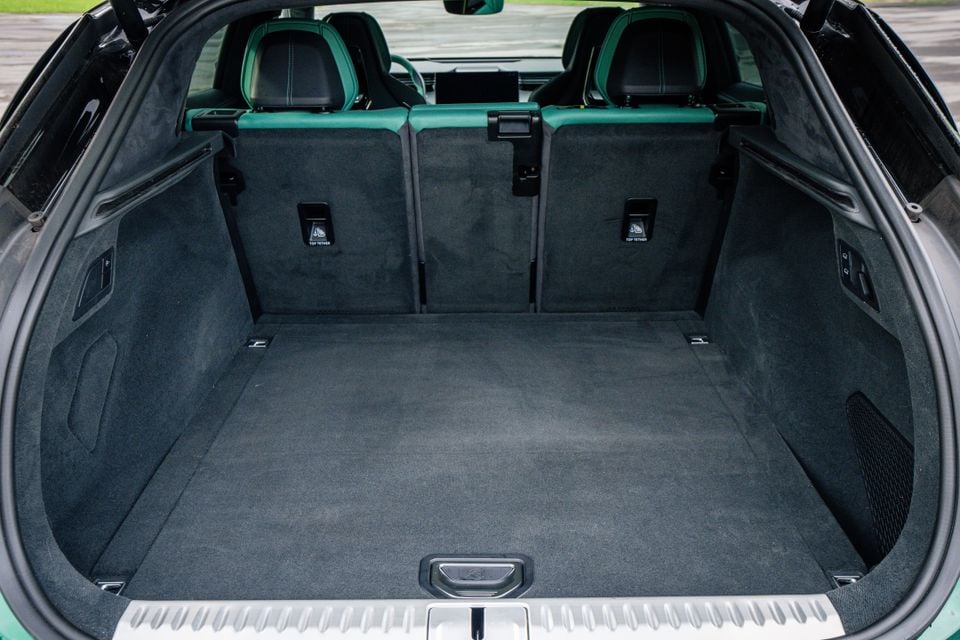 Boot of the 2027 Lotus Eletre X seen through the open tailgate, with carpeted load floor and black and green rear seats upright
