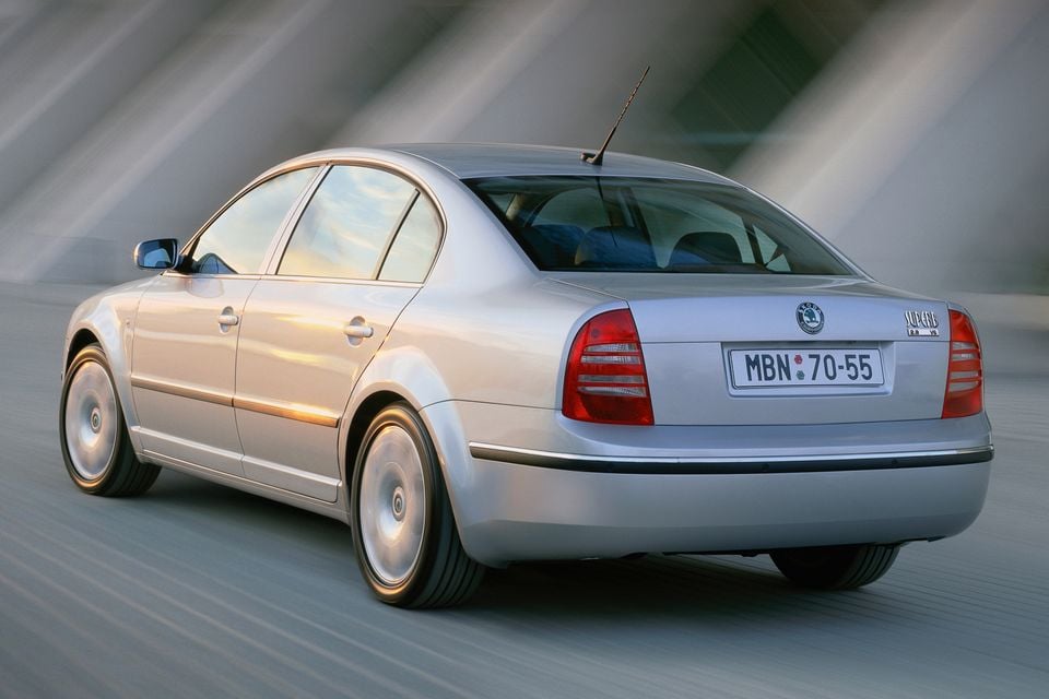 A silver Skoda Superb sedan seen from the rear three-quarter angle while driving