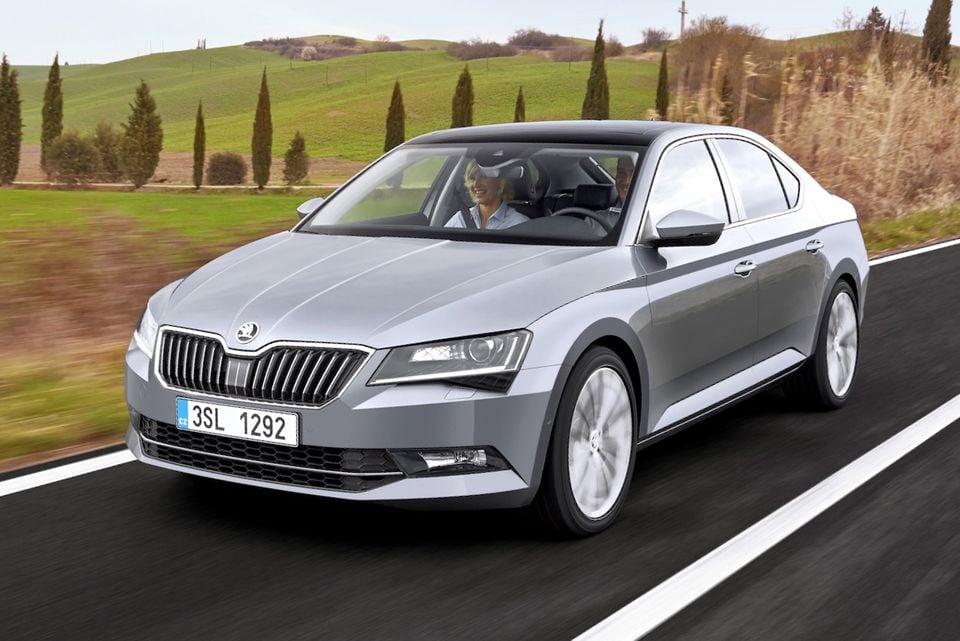 A silver Skoda Superb sedan driving along a country road, seen from the front and side