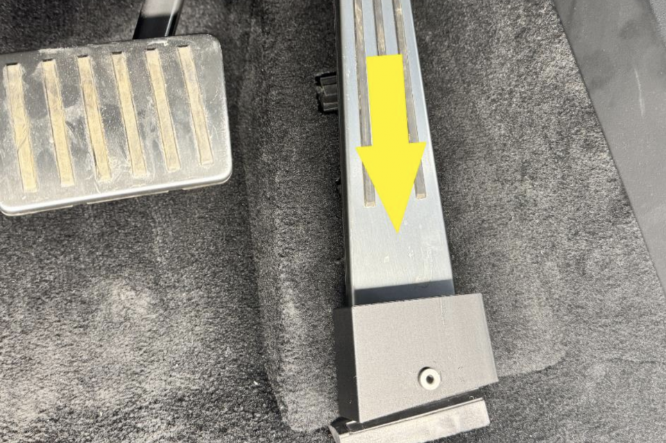 A Cybertruck accelerator pedal with a drilling jig to prepare for the rivet install