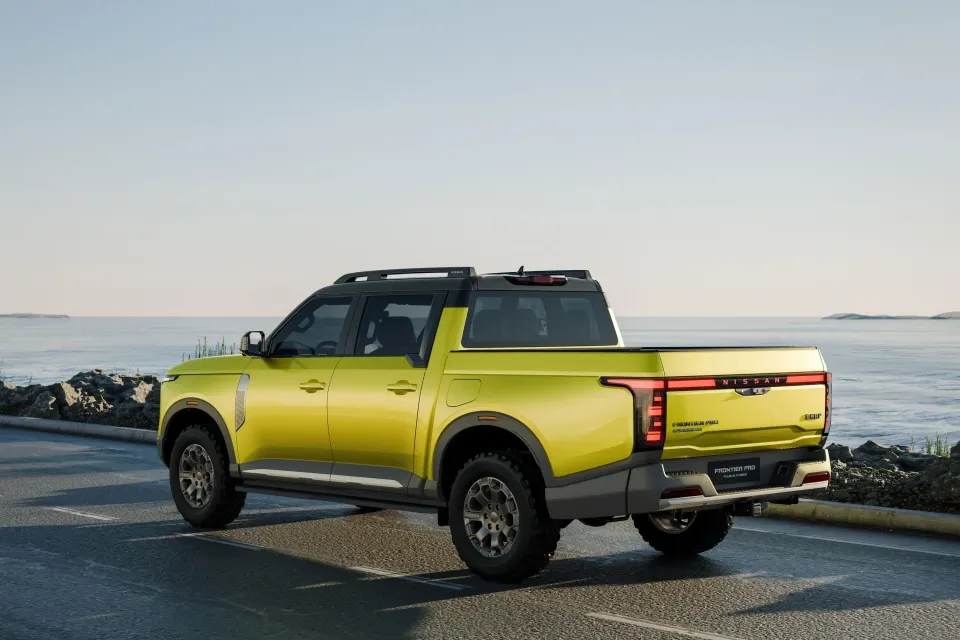 A bright yellow Nissan Frontier Pro plug-in hybrid dual-cab ute seen from the rear quarter, parked on a coastal road beside the sea