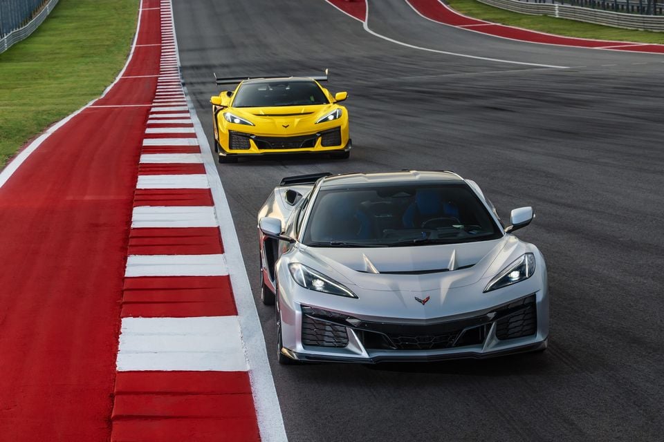 Front view of a Corvette ZR1X in Blade Silver Metallic and a ZR1 with ZTK Performance Package in Competition Yellow Tintcoat Metallic driving on a race track. With ZR1 and ZR1X, Chevrolet now has the most powerful American performance car duo of any auto manufacturer. Preproduction model shown, actual production model may vary.