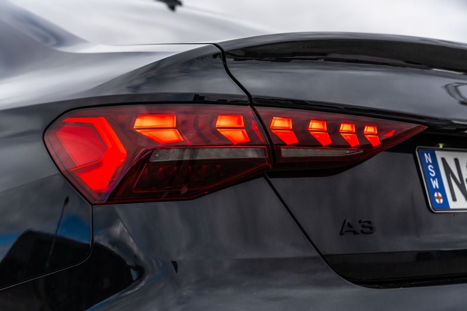 Close-up of the rear tail light on a dark grey 2026 Audi A3 sedan, with an NSW number plate visible