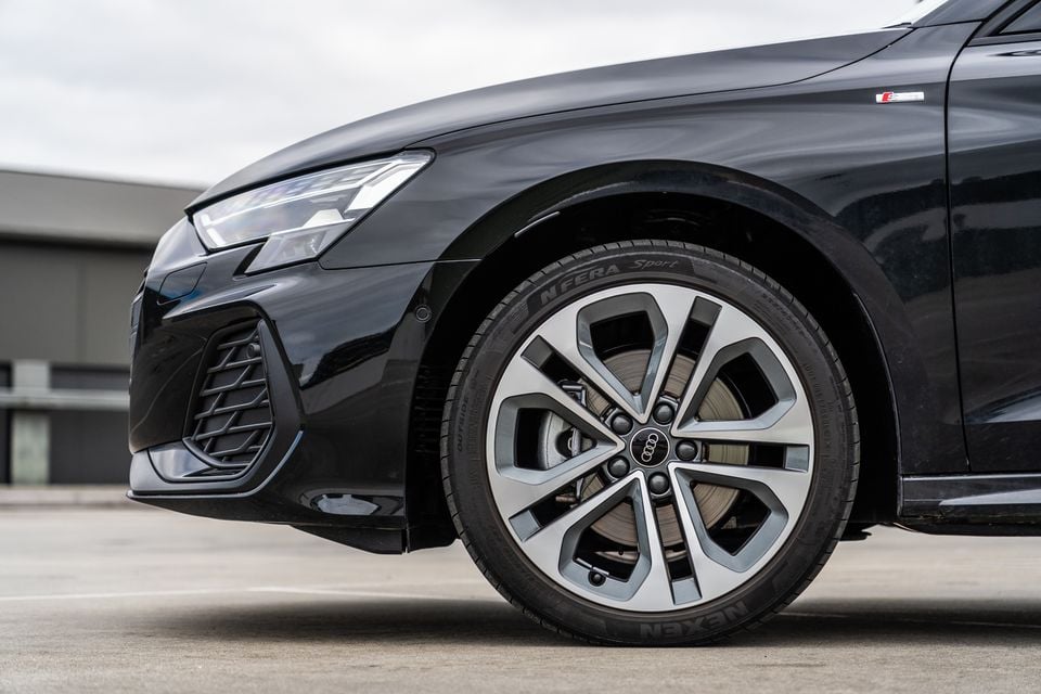 Close-up of the front wheel and alloy rim on a black 2026 Audi A3 S line sedan, fitted with Nexen N'Fera Sport tyres