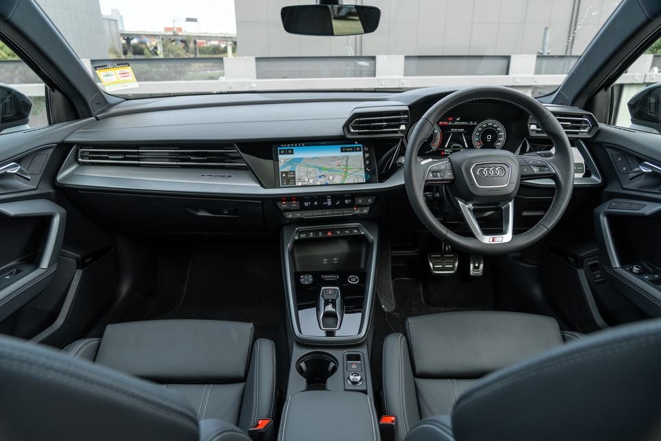 Interior of a 2026 Audi A3 sedan S line showing the dashboard, steering wheel, touchscreen infotainment display with navigation, centre console, and front seats
