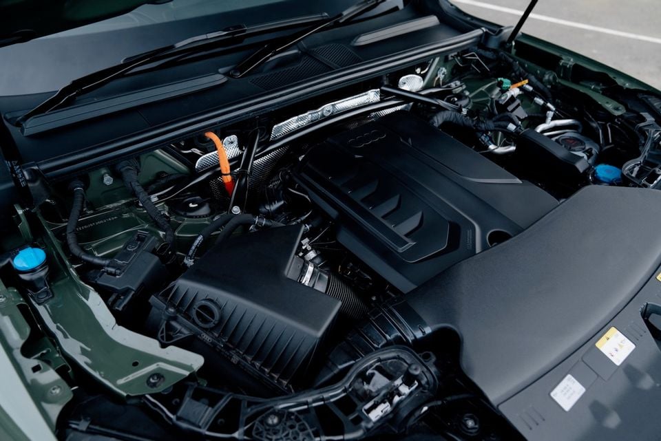 The engine bay of a 2026 Audi Q5 e hybrid Sportback, showing the turbocharged engine with hybrid components including an orange high-voltage cable