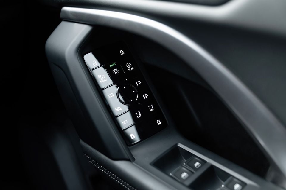 Door panel controls of a 2026 Audi Q5 e hybrid Sportback, showing mirror adjustment, seat memory, lighting and window switch controls