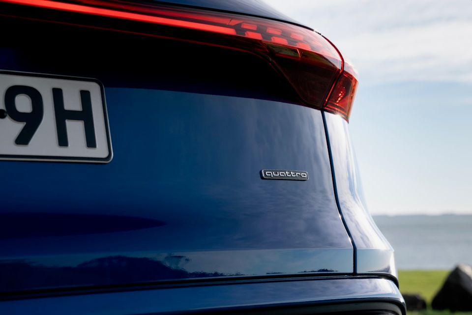 Close-up of the rear of a blue Audi Q5 e hybrid SUV showing the quattro badge and tail light