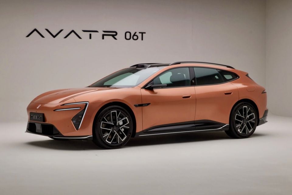 An orange Avatr 06T wagon-style electric car seen from the front-side angle in a studio setting