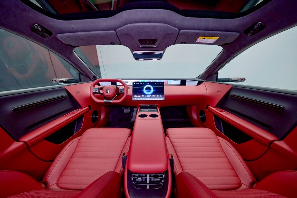 Interior of the 2026 Avatr 06T showing bold red leather seats, steering wheel, and central touchscreen infotainment display with a panoramic glass roof