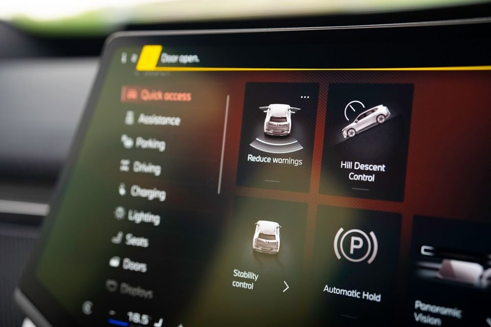 Touchscreen infotainment display in a 2026 BMW iX3 showing quick access menu with options including Hill Descent Control, Stability Control, Automatic Hold and Reduce Warnings