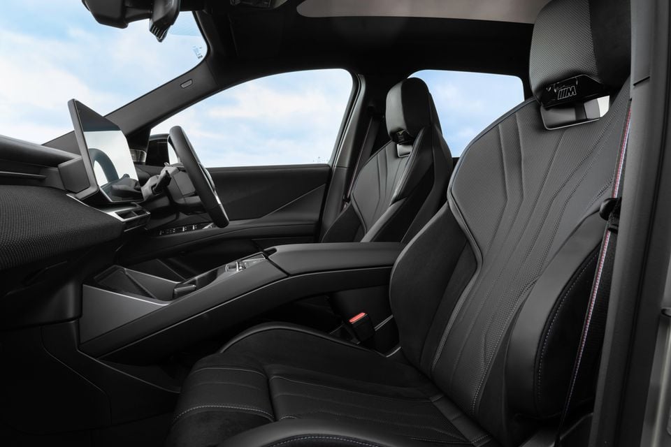 Interior of a 2026 BMW iX3 M Sport Pro showing black leather M Sport front seats, centre console, steering wheel and infotainment screen