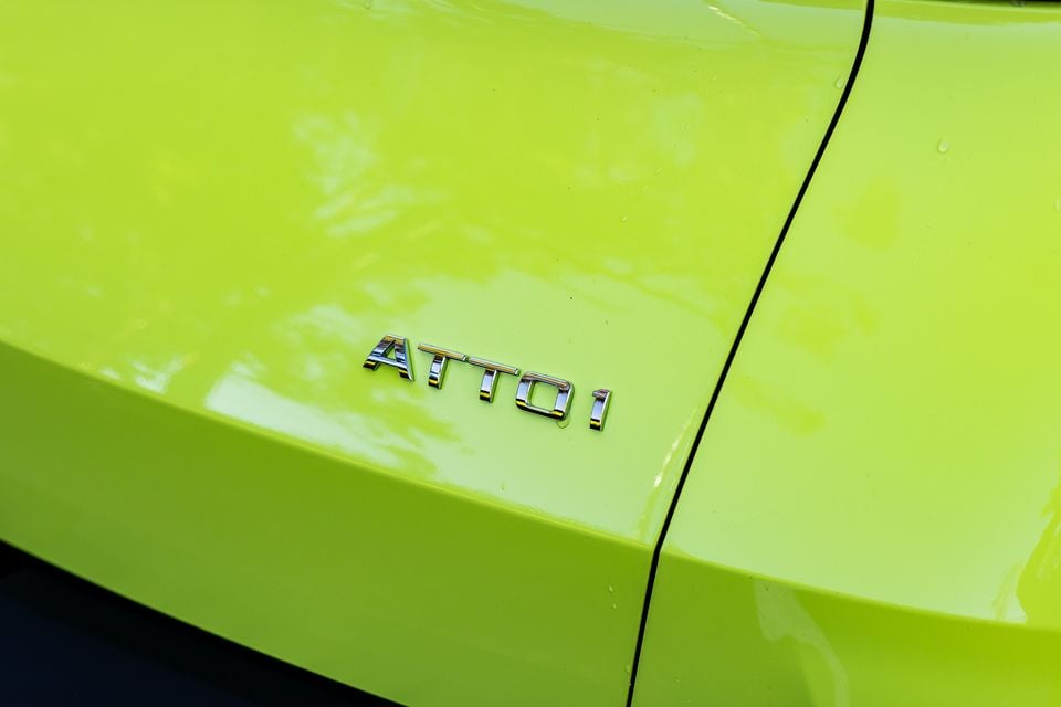 Close-up of the chrome 'Atto 1' model badge on a lime green BYD Atto 1