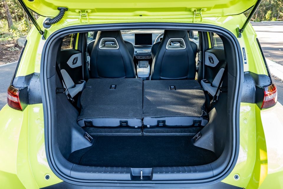 Boot of a yellow-green 2026 BYD Atto 1 hatchback with rear seats folded flat, viewed from the rear with the tailgate open