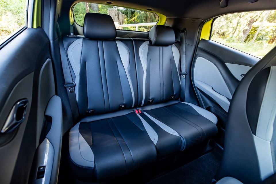 Rear seat interior of a 2026 BYD Atto 1, showing a two-tone dark grey and light grey bench seat with sculpted upholstery and centre seatbelt buckle
