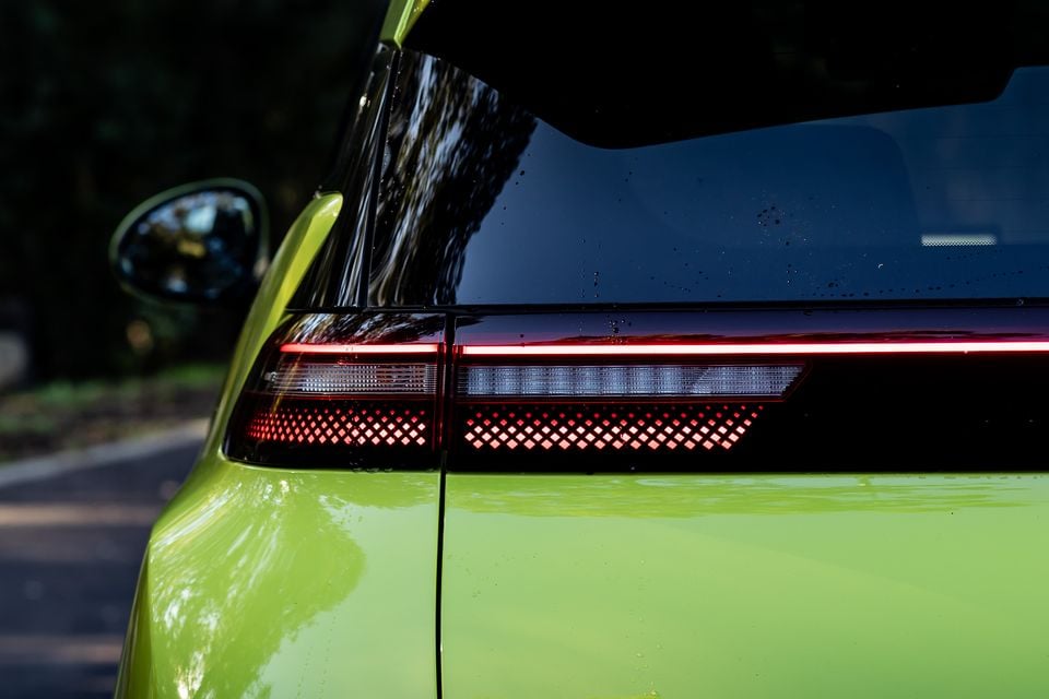 Close-up of the rear tail light on a lime green 2026 BYD Atto 1, showing a LED light bar with a diamond-pattern cluster