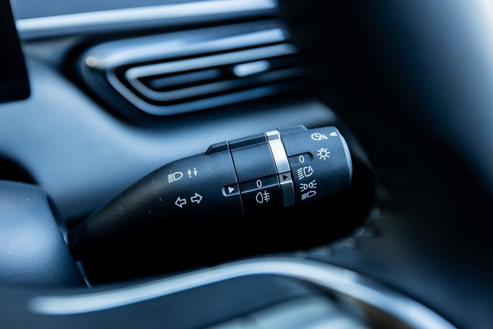 Close-up of the indicator and headlight stalk controls on the steering column of a BYD Atto 1