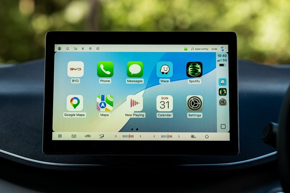 Apple CarPlay interface displayed on the BYD Atto 1's infotainment touchscreen, showing apps including Google Maps, Waze, Spotify, Messages and Settings