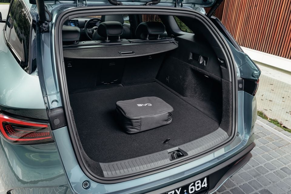 Open boot of a BYD Seal 6 Touring SUV showing a carpeted cargo area with a BYD-branded charging bag, seen from the rear