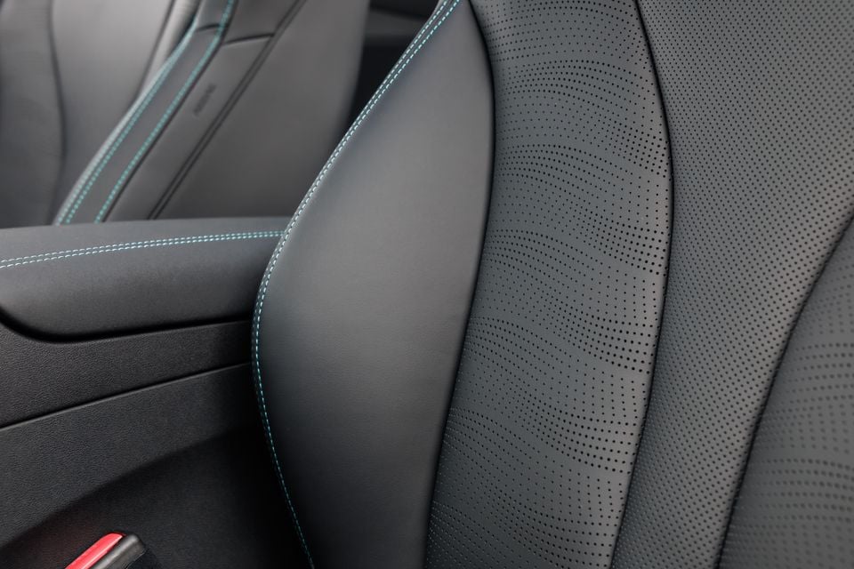 Close-up of dark perforated leather car seat with teal contrast stitching detail in a 2026 BYD Seal 6 Touring