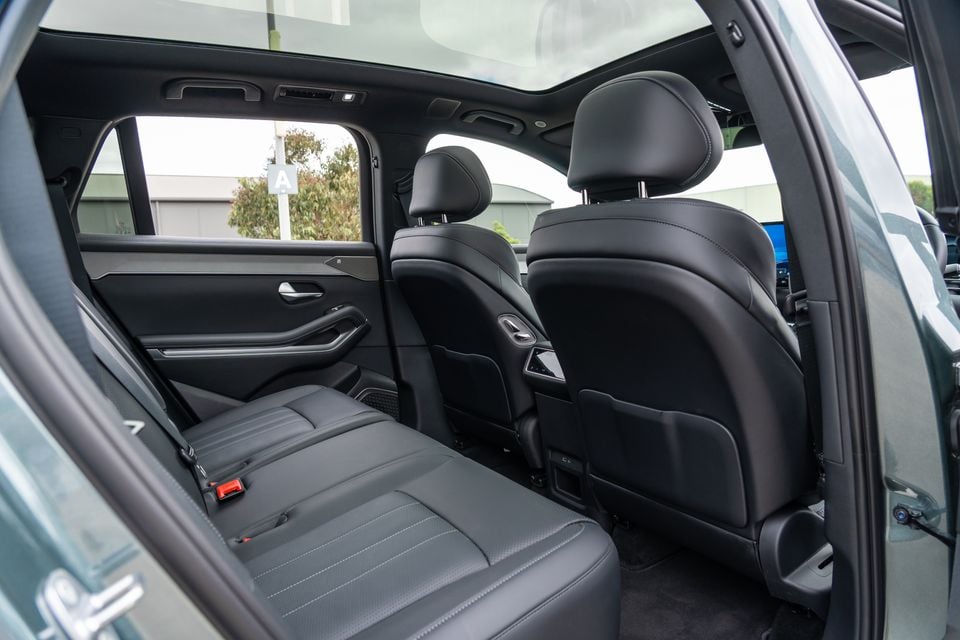 Rear passenger cabin of a 2026 BYD Sealion 8 showing dark leather rear seats, seatbelts, and a panoramic sunroof overhead