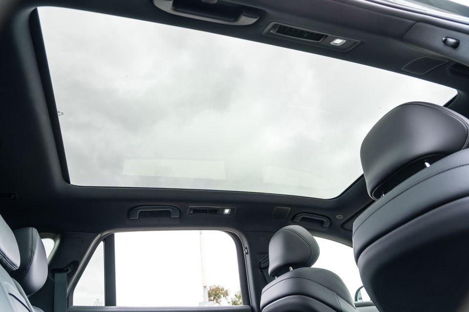 Interior view of a 2026 BYD Sealion 8 showing a large panoramic sunroof and black leather rear seats