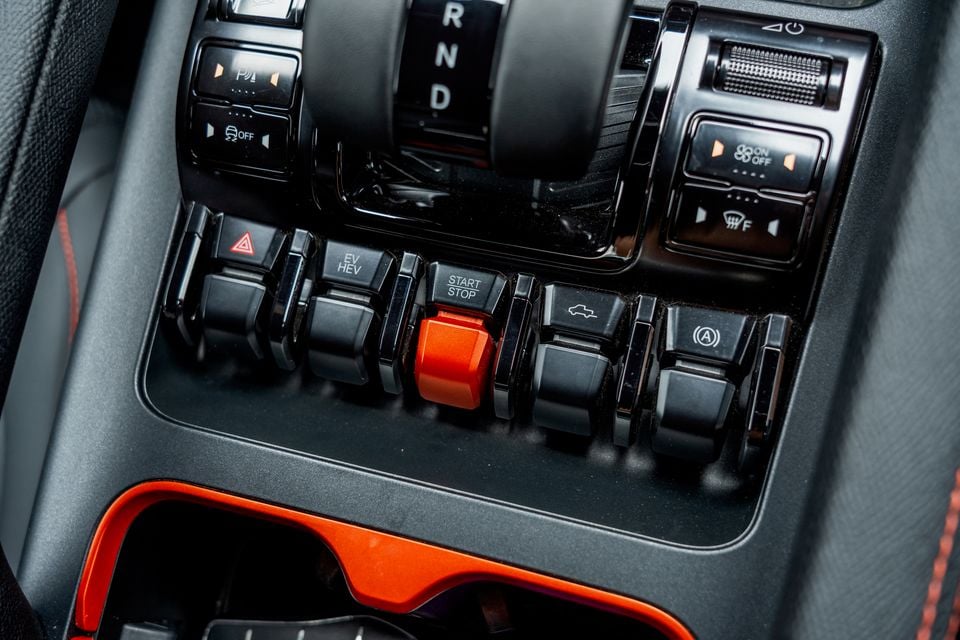Centre console of the 2026 BYD Shark 6 with toggle switches, an orange start/stop button, gear selector and EV/HEV mode switch