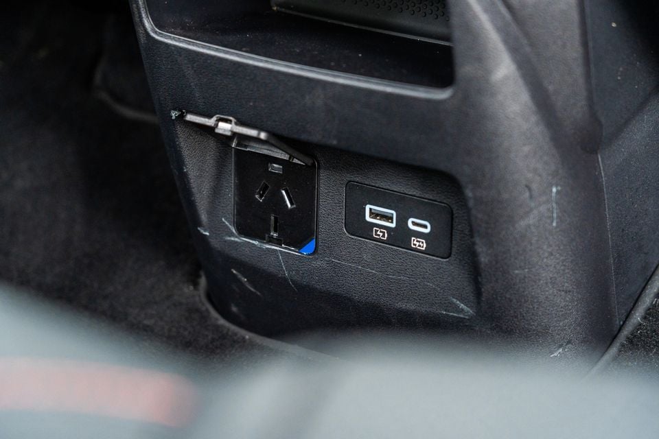 Rear of the centre console in a 2026 BYD Shark 6 Premium with a 240-volt power outlet plus USB-A and USB-C charging ports