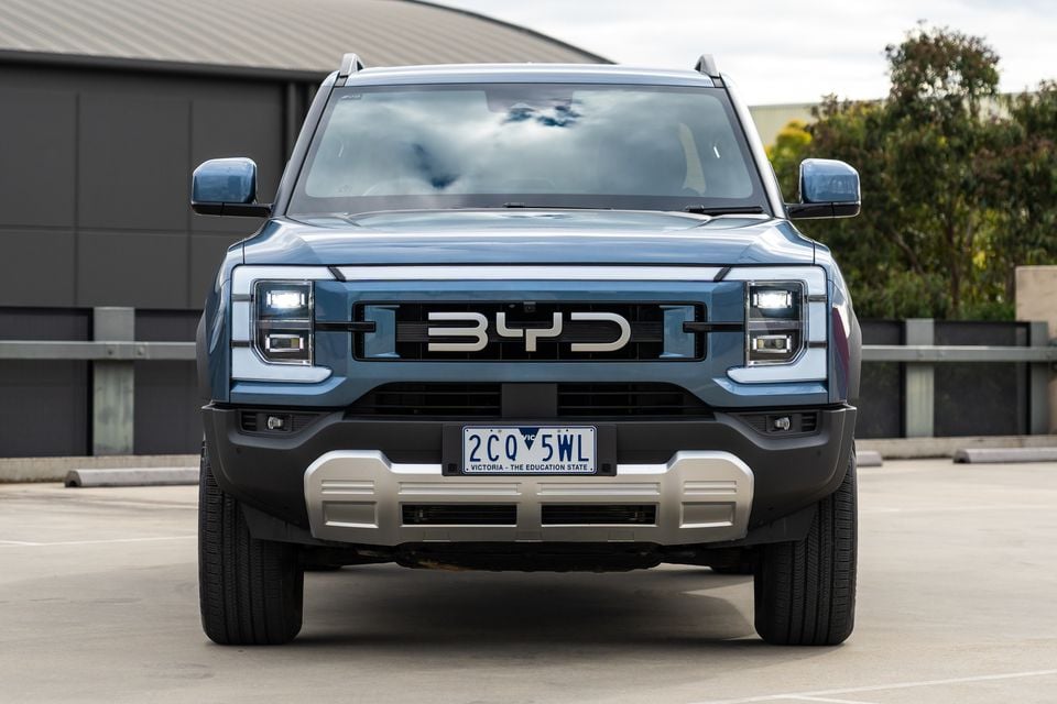 A blue 2026 BYD Shark 6 Premium ute seen from the front, parked on a rooftop car park