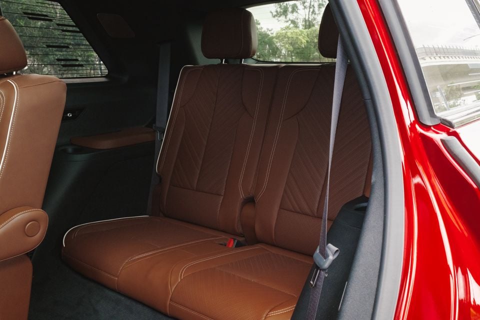 Third-row seats with tan leather upholstery inside a 2026 Cadillac VISTIQ, viewed from the side door opening