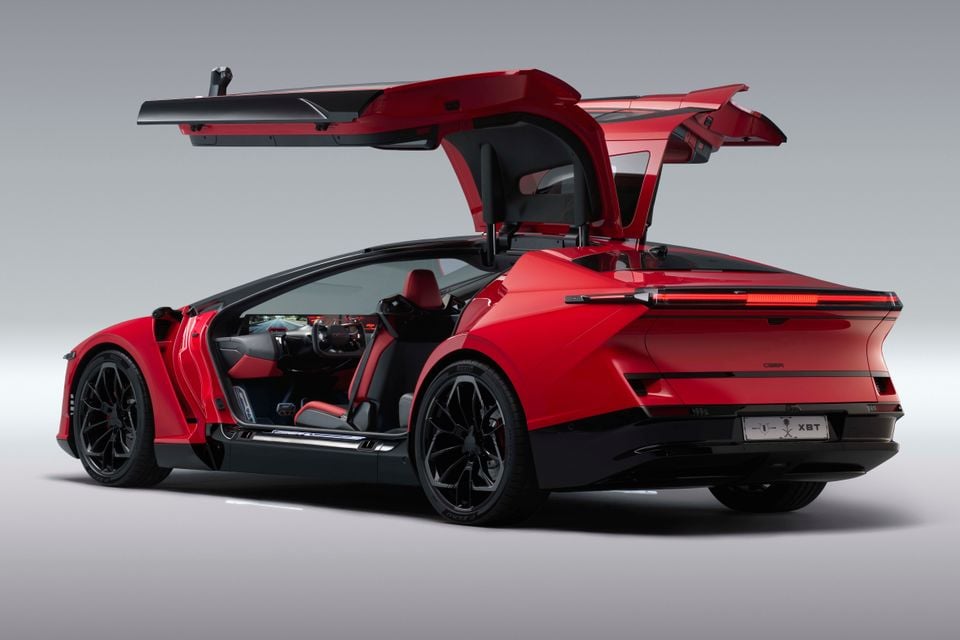 A red 2026 Ceer Exobot sedan shown with its butterfly doors open, revealing the red and black interior, on a plain studio background