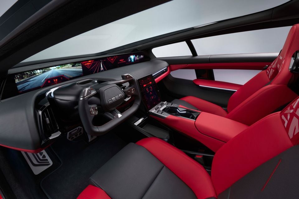 The red and black interior of a 2026 Ceer Exobot sedan, showing a wide digital instrument display, steering wheel and front red leather seats