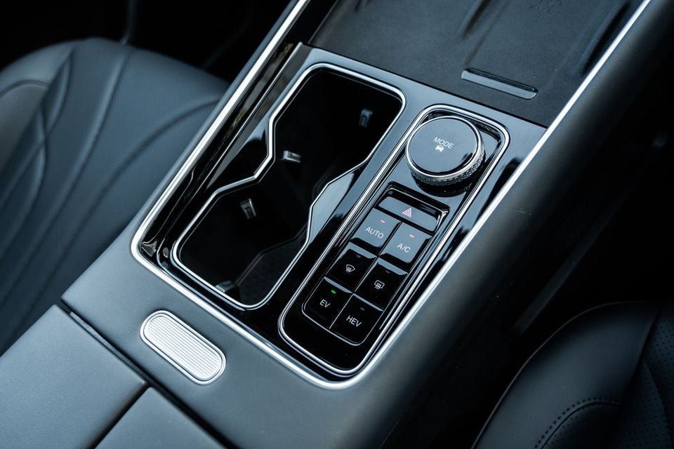 Centre console of the 2026 Chery Tiggo 9 Super Hybrid showing cup holders, a drive mode dial, climate control buttons, and EV/HEV mode selector switches