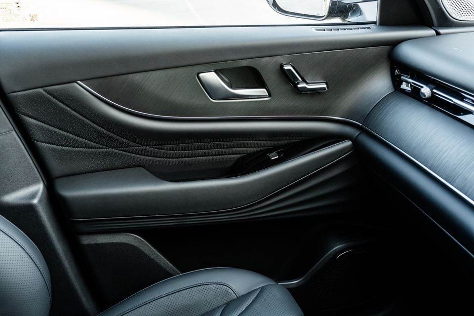 Interior door panel of a 2026 Chery Tiggo 9 showing sculpted black leather trim, door handle, and window controls