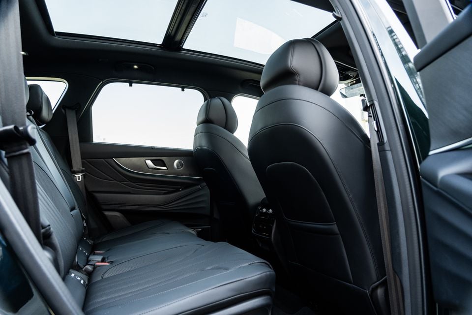 Rear interior of a 2026 Chery Tiggo 9 SUV showing black leather rear seats, panoramic sunroof, and door speaker