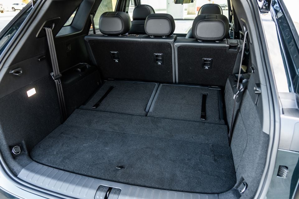 Boot area of a 2026 Chery Tiggo 9 Super Hybrid SUV with rear seats folded flat, showing a large carpeted cargo space with top tether anchor points visible on the seatbacks.