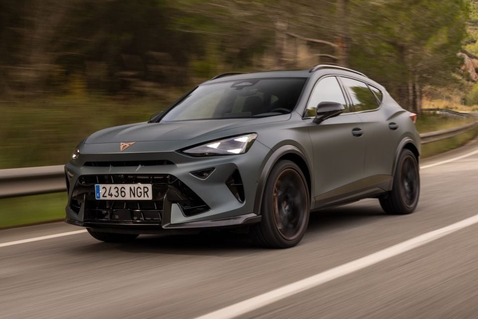 A grey 2026 Cupra Formentor VZ5 SUV driving along a road, seen from the front-side angle