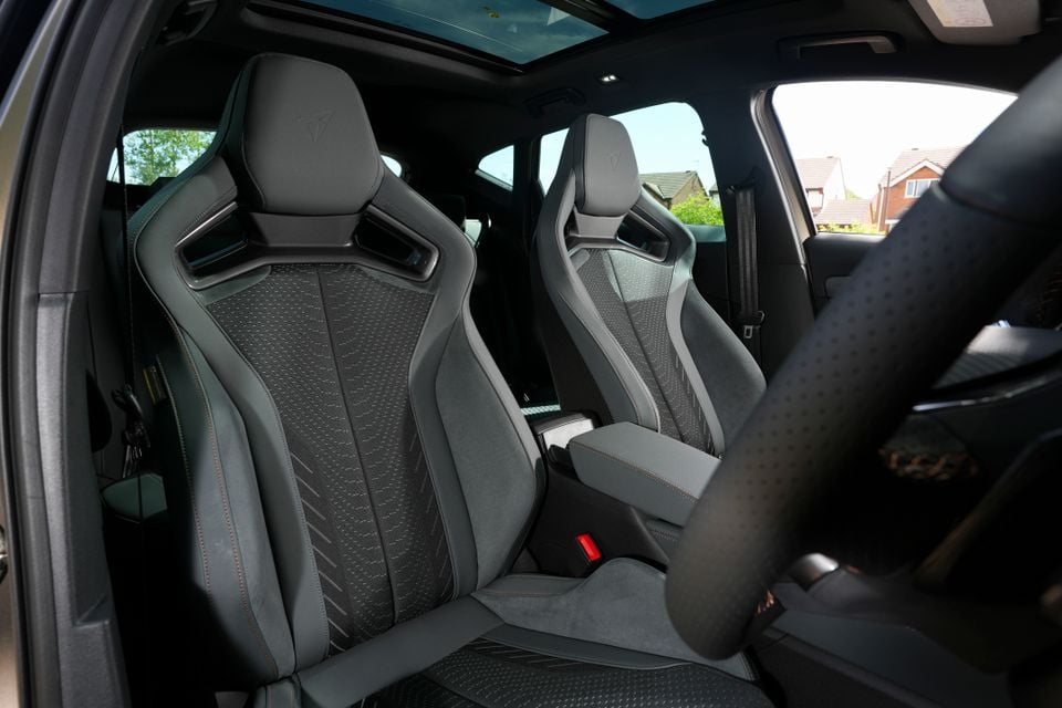 Interior of a 2026 Cupra Formentor VZ5 showing dark sport bucket seats with Cupra logo embossed on the headrests and a panoramic sunroof above