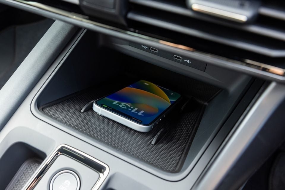 A smartphone wirelessly charging in the centre console cubby of a 2026 Cupra Formentor VZX, with USB-C ports visible above